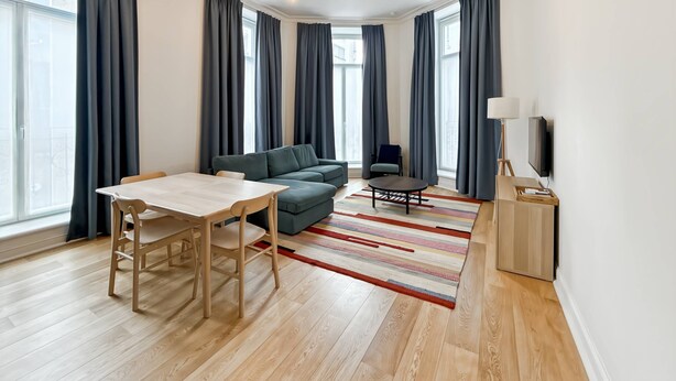 Un salon moderne avec un canapé, une table à manger et un téléviseur.