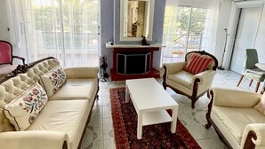 A spacious living room with a fireplace, two sofas, a coffee table, and a patterned rug.