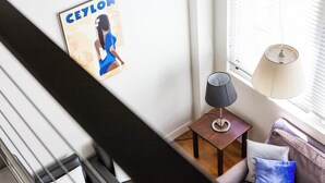 A modern living room with a sofa, a lamp, and a poster on the wall. - Oversized Designer Warehouse in Surry Hills / City (Surry Hills)