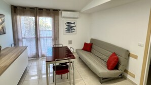 A compact living space with a dining table, a sofa, and a chair. - Foyer in Bibione With 1 Bedrooms and 1 Bathrooms (San Michele al Tagliamento)