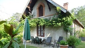 Una casa con un patio, una mesa y sillas.