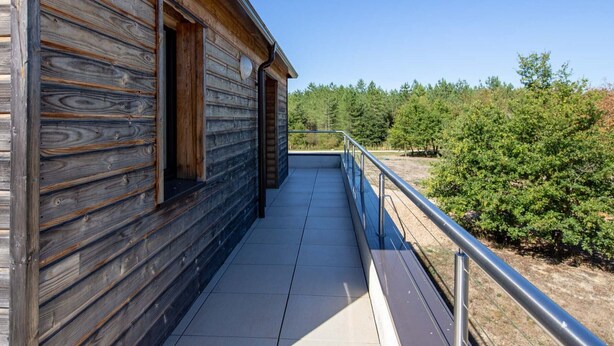 A wooden cabin with a balcony overlooking a forested area. - Cottage in Sologne with leisure and activities nearby (Jouy-le-Potier)