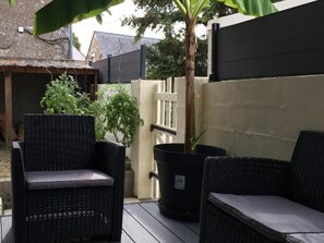 A patio area with wicker furniture, a potted plant, and a thatched-roof structure. - Family home near castles, Loire cycling, private parking (Messas)