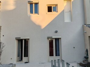 A building with two ground-floor windows, a small balcony, and a door. - Family home near castles, Loire cycling, private parking (Messas)