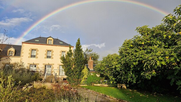 A two-story house with a garden in front, a visible rainbow, and a clear sky. - Large Cottage in Briare - Pets and Private Parking (Briare)