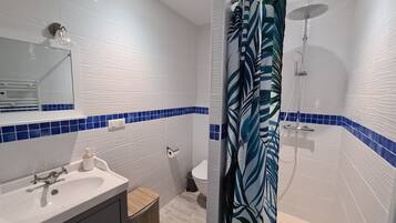A bathroom with a white sink, mirror, and blue-tiled walls.