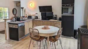 Cuina compacta amb zona de dinar, equipada amb microones, cafetera i forn integrat.