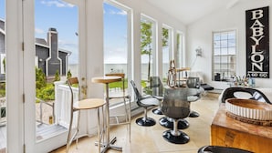 Un intérieur moderne avec de grandes fenêtres, un espace bar et une vue sur la mer.
