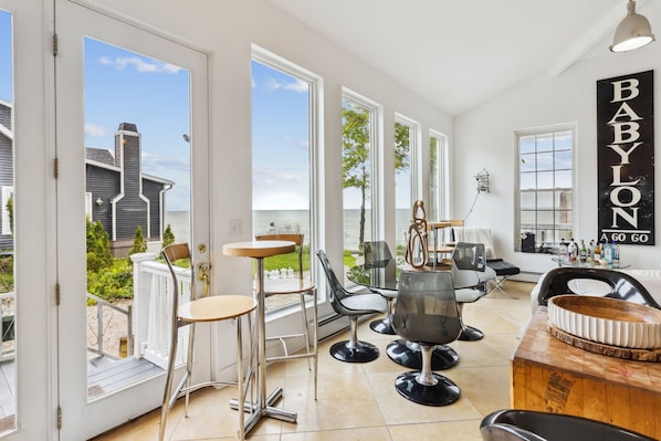 Un interior moderno con ventanas amplias, una zona de bar y vista al mar.
