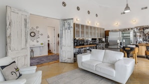 Un salon spacieux avec un canapé blanc, une table basse et un élément décoratif mural.
