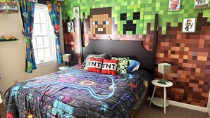 A bedroom with a Minecraft-themed bedspread, wall art, and decor. - Game Night Suite at Jiminy Peak Ski OnOff Sleeps 4 (Hancock)