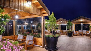 Un espacio al aire libre con mobiliario de madera y plantas en macetas.