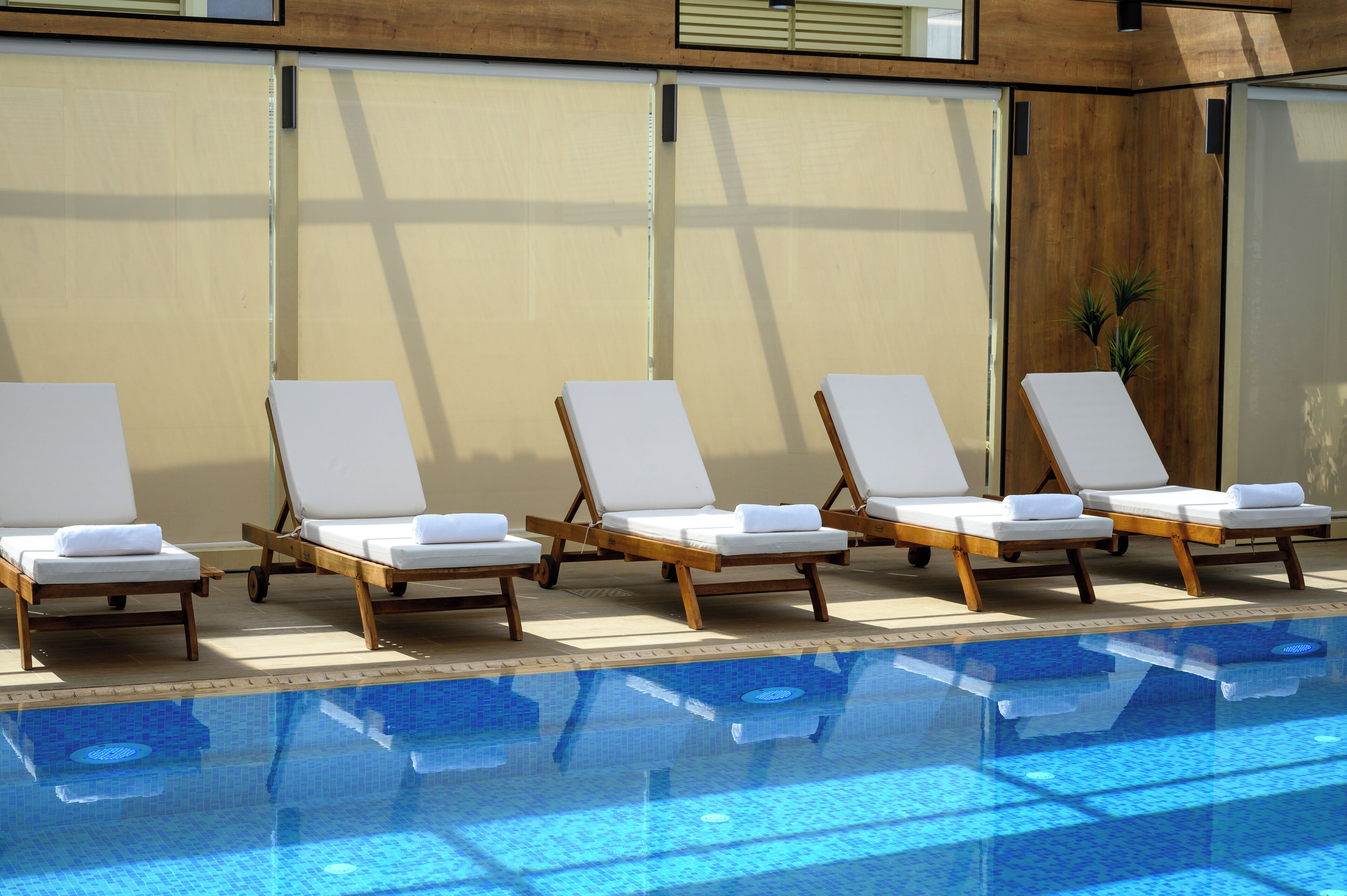 A poolside area with lounge chairs and a clear pool.