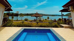 A swimming pool with a view of a lake and mountains in the background. - Platinum Blue Island Resort (Akosombo)