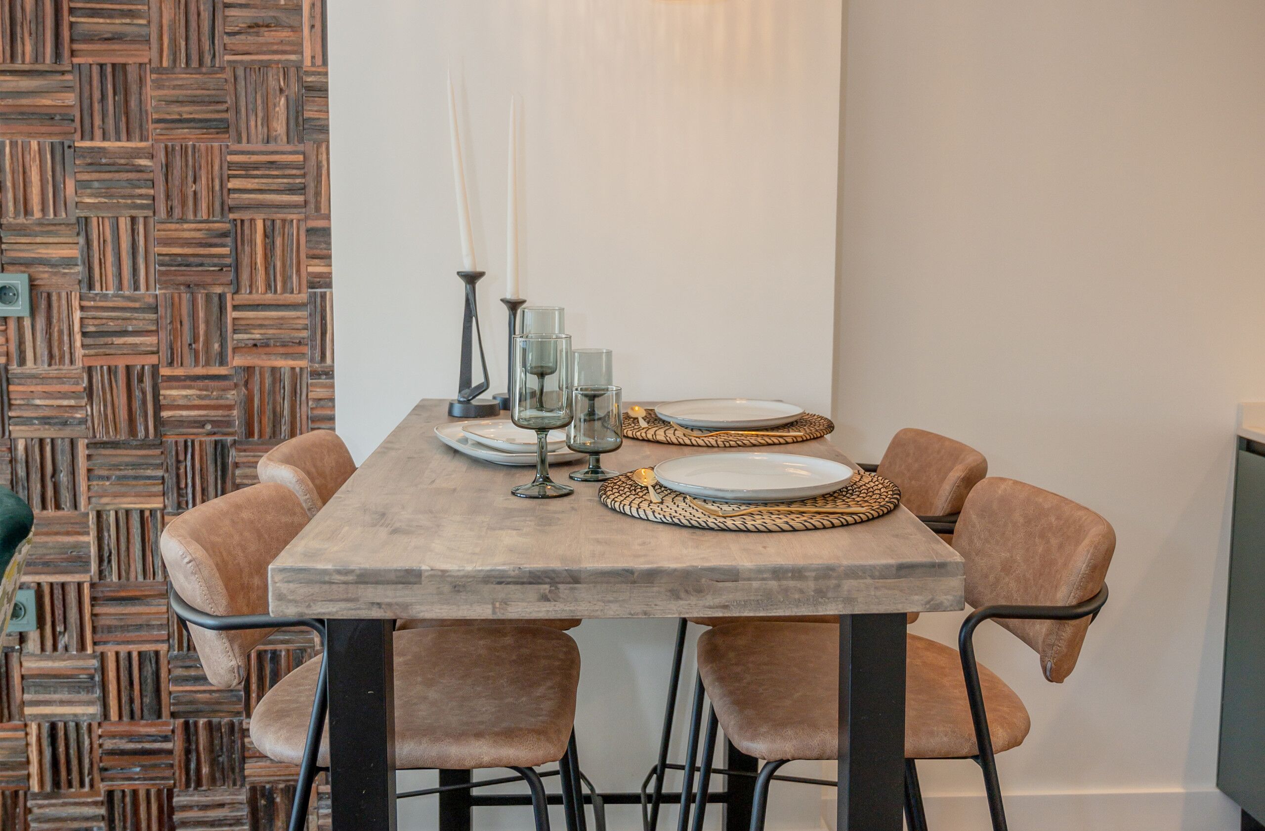 Comedor con mesa de madera dispuesta para cuatro personas, rodeada de sillas acolchadas.