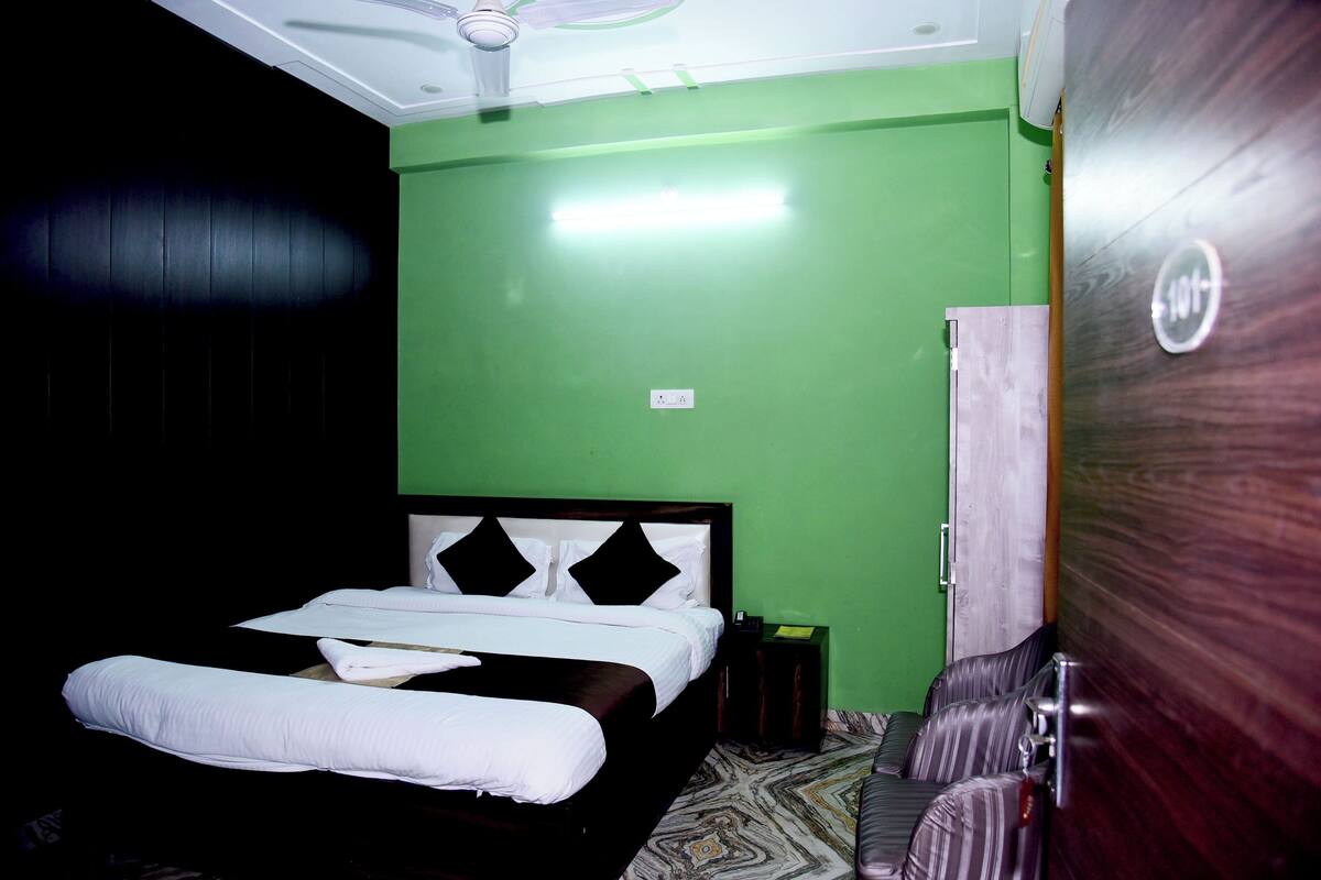 A room with a bed, a wardrobe, and a ceiling fan.