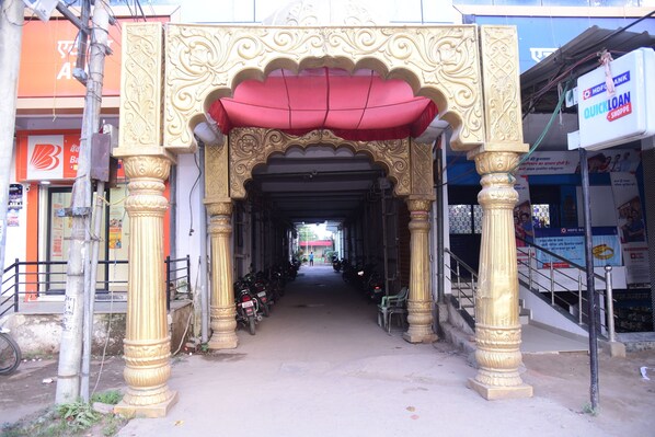 An ornate entrance with a red canopy, leading to a covered walkway. - Hotel Shree Mahalaxmi (Karchana)