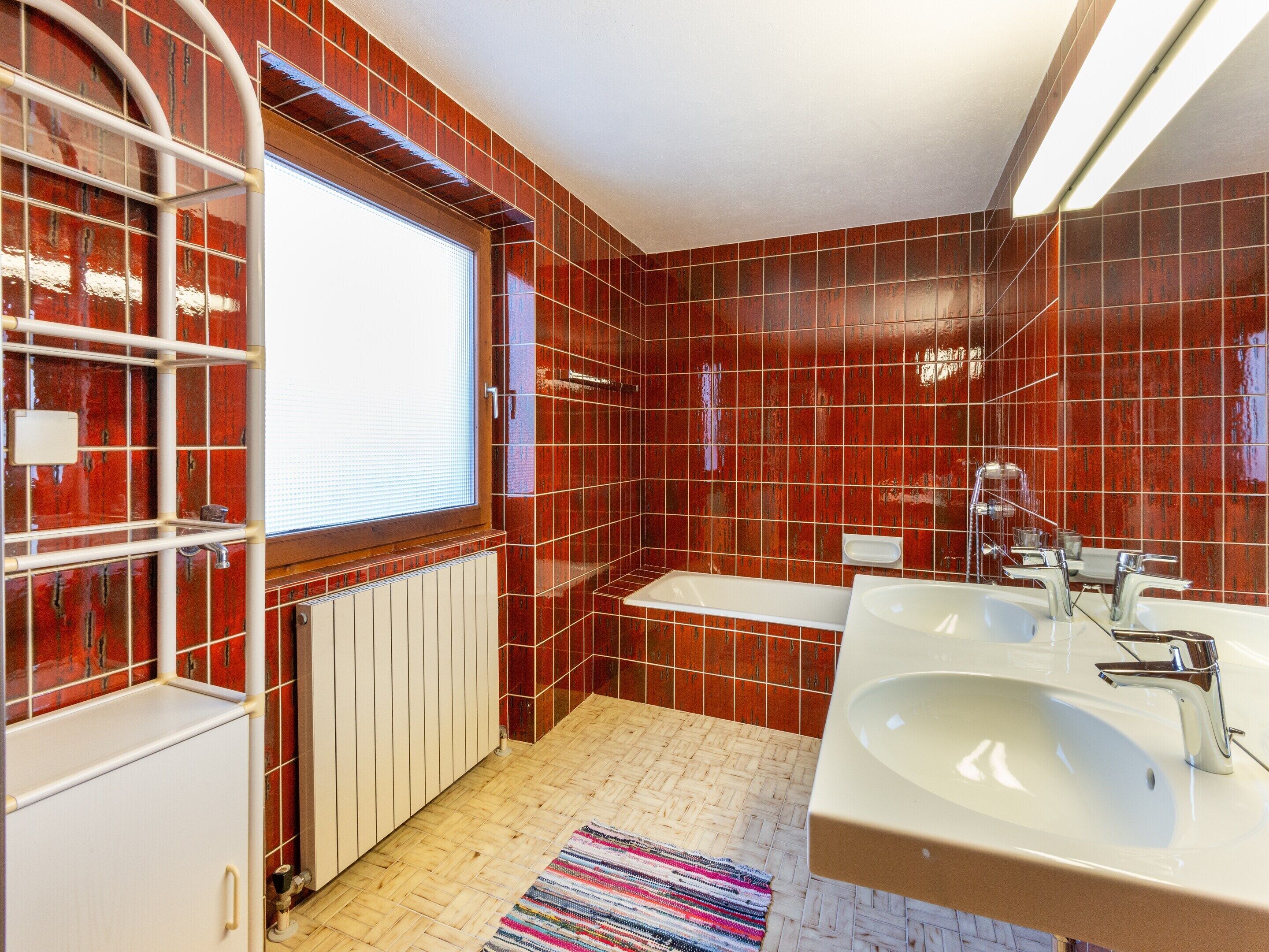 Un bany amb banyera, un lavabo i una finestra.