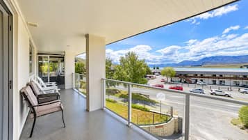 A balcony with a view of a parking lot and mountains.