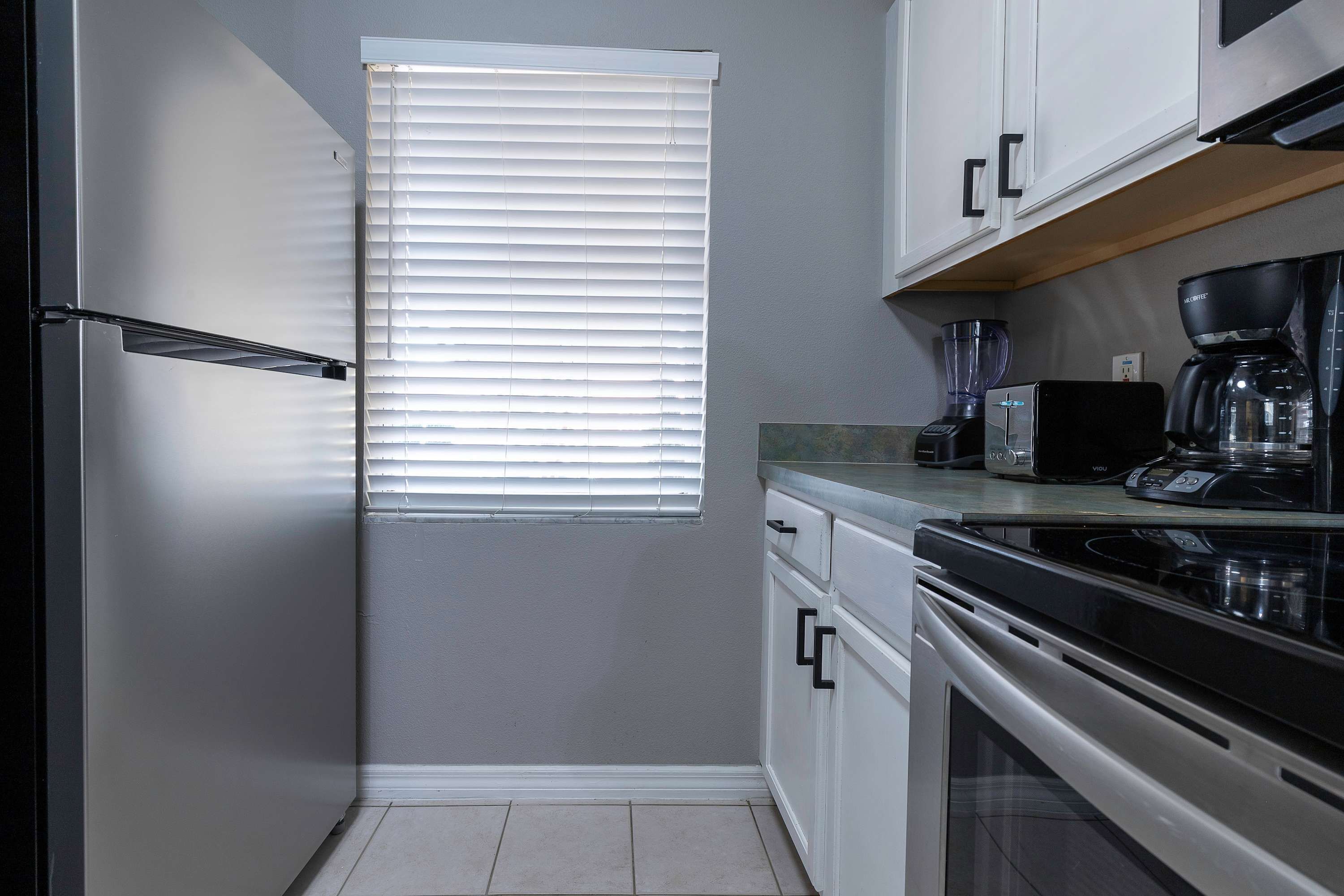 A compact kitchen with a built-in oven, a coffee maker, and a toaster.