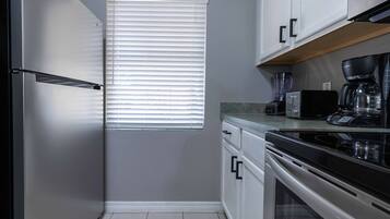 A compact kitchen with a built-in oven, a coffee maker, and a toaster.