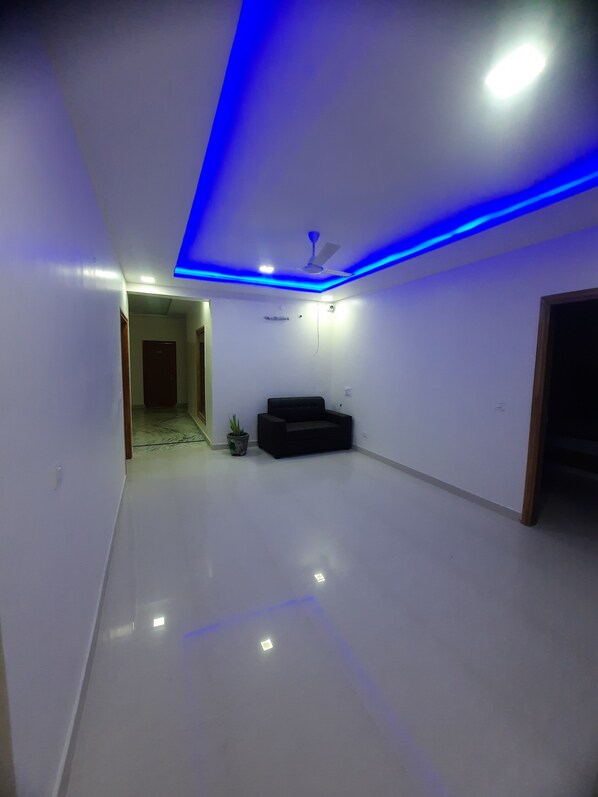A spacious room with a flat floor, a ceiling fan, and a potted plant. - THE HIGHCLASS HOTEL (Bathinda)