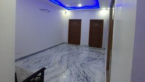 Ein Zimmer mit Marmorboden, zwei Holztüren, einem Deckenventilator und blauer LED-Beleuchtung.