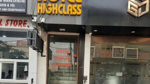 Ein Hotel Eingang mit einem Schild, auf dem 'HOTEL HIGHCLASS' und eine Kontaktnummer stehen.
