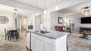 A modern kitchen with granite countertops, a dishwasher, and pendant lighting. - Sandy Feet Retreat: Like-New, Harbor Club South Haven, Year-Round Pool & Hot Tub (South Haven)