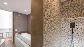 A modern bathroom with a large bathtub, a shower area with a mosaic wall, and a glass partition.