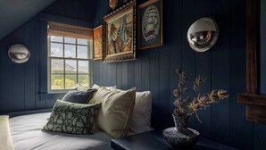 A room with a bed, a window, and a wall-mounted clock. - Beautiful Historic Home | Heated Pool & Hot Tub (Nantucket)