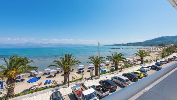 A coastal view with a beach, parked cars, and umbrellas. - Aphrodite Beach Hotel Corfu (Corfu)