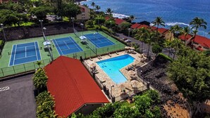 An aerial view of a resort with multiple tennis courts, a swimming pool, and a view of the ocean. - Kksr#48 Beautiful Townhome, Steps from the Pool/Beach, Remodeled, AC in unit! (KAILUA KONA)
