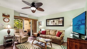 A living room with a sofa, armchair, coffee table, and television. - Kksr#48 Beautiful Townhome, Steps from the Pool/Beach, Remodeled, AC in unit! (KAILUA KONA)
