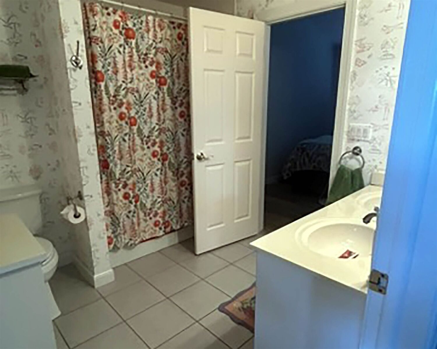 A bathroom with a toilet, a sink, and a shower area.