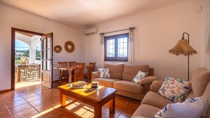 Ein Wohnzimmer mit einer Couch, einem Couchtisch und einem Essbereich mit Stühlen und einem Tisch.