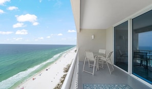 A balcony with a view of a beach and ocean.
