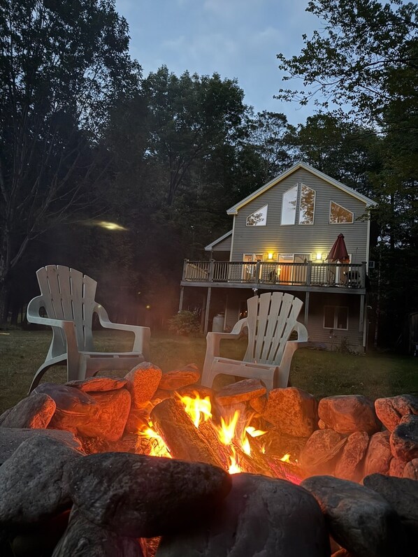 A house with a deck and a fire pit with rocks. - All-Season Lake Pauline Retreat, 2 mi to Okemo (Ludlow)