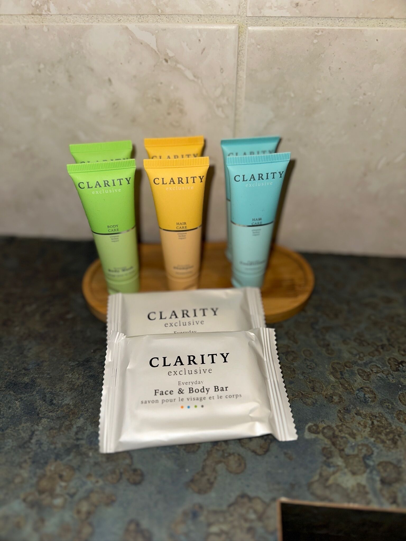 Una encimera con cuatro tubos de productos corporales exclusivos Clarity y un paquete de jabón Clarity Everyday para rostro y cuerpo.