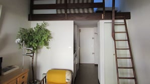 A room with a bunk bed, a desk, a chair, a plant, a ladder, and a door. - 40m² apartment ideal for 2 or 4.  50 m from the sea. quiet area. (Agde)