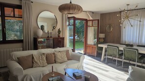 A modern living room with a sofa, coffee table, and dining area. - Luxury House in Picos de Europa Liebana garden with chill out area (La Frecha)