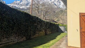 A house with a wooden deck and a view of snow-capped mountains. - Luxury House in Picos de Europa Liebana garden with chill out area (La Frecha)
