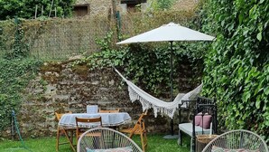 A rustic stone building with a tiled roof, surrounded by lush greenery and a grassy yard. - Luxury House in Picos de Europa Liebana garden with chill out area (La Frecha)