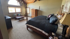 A bedroom with a large bed, a wooden wardrobe, a desk, and a window with curtains. - Spacious 6-bedroom 6.5 bath house in charming Crested Butte with gym and hot tub (Crested Butte)