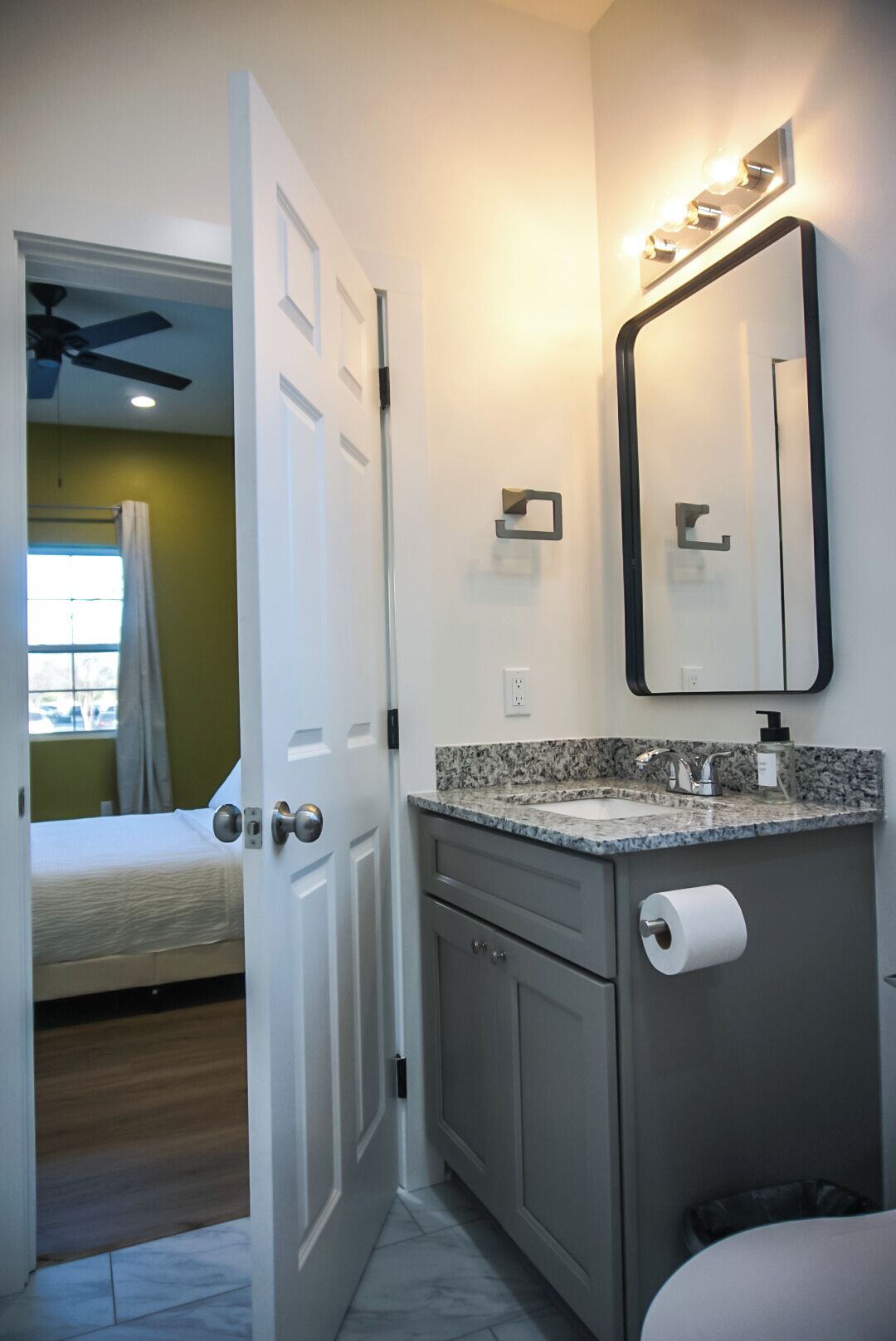Une salle de bain comprenant un meuble-lavabo, des toilettes et un espace douche.