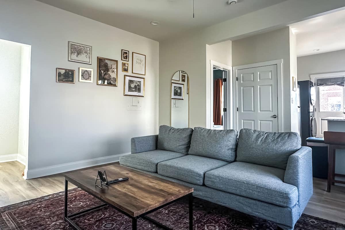 A living room with a gray sofa, a wooden coffee table, and a ceiling fan.