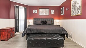 A bedroom with a large bed, a wooden dresser, and framed pictures on the wall. - Beautiful 3 bedroom uniquely designed home for small to large families! Pets ok! (Davenport)