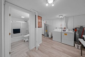 A modern bathroom with a shower, toilet, and a large mirror.