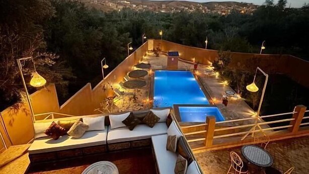 Μια ταράτσα με πισίνα, χώρους για καθιστικό και θέα στην πόλη.