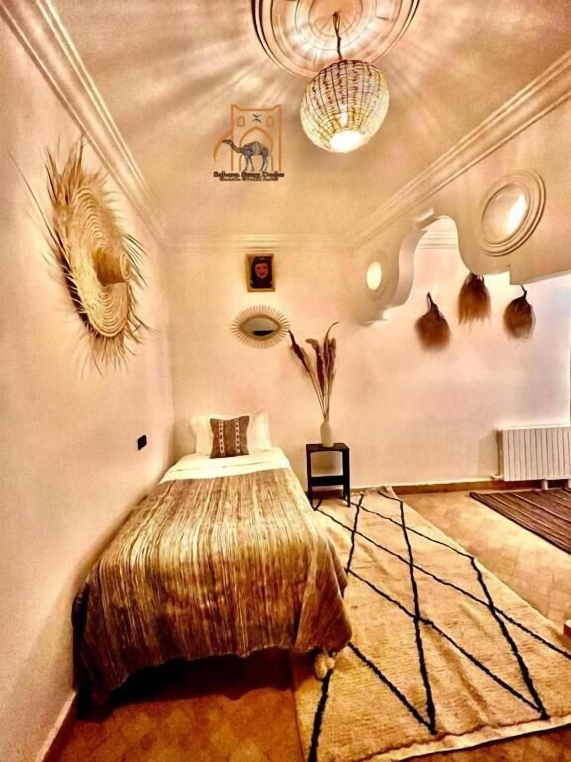 A bedroom with a bed, a mirror, a wall-mounted light fixture, and a radiator.